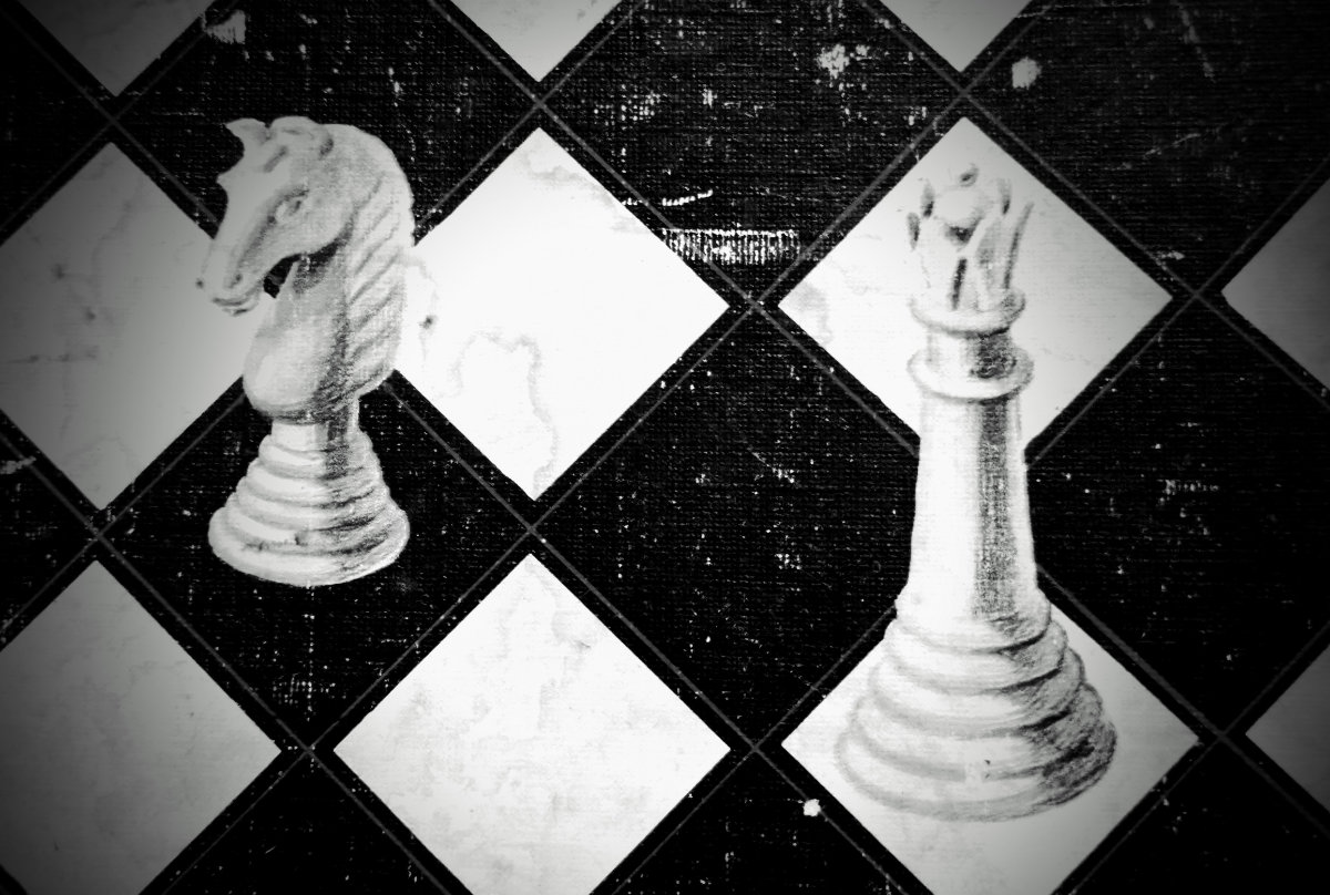 a chess knight and queen on a worn board