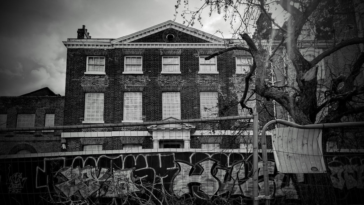 An abandoned building beneath a dark blue night sky